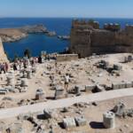 The ancient Lindos Acropolis, perched atop dramatic cliffs, overlooks the charming town and harbor on the Greek island of Rhodes.