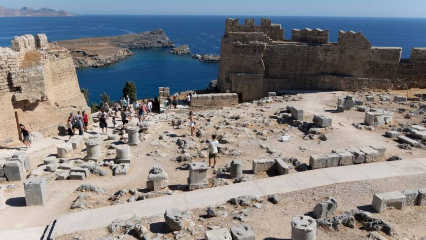 The ancient Lindos Acropolis, perched atop dramatic cliffs, overlooks the charming town and harbor on the Greek island of Rhodes.