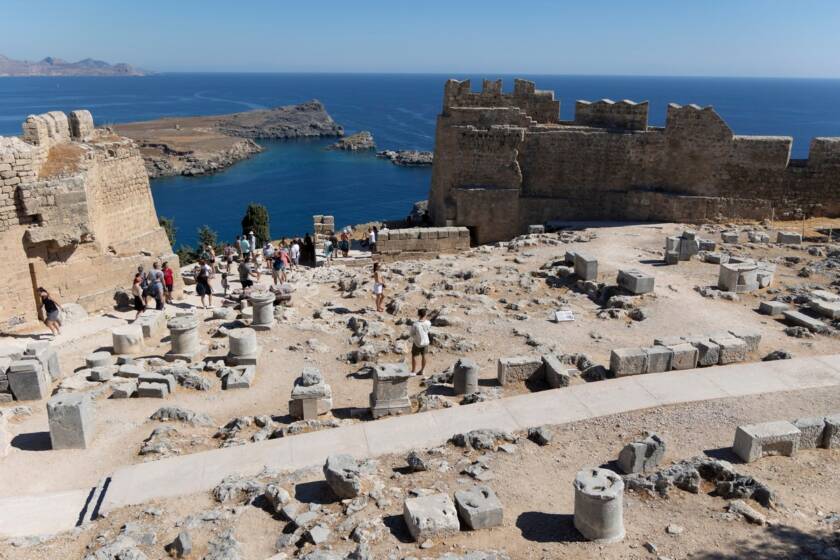 The ancient Lindos Acropolis, perched atop dramatic cliffs, overlooks the charming town and harbor on the Greek island of Rhodes.