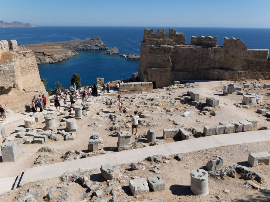 The ancient Lindos Acropolis, perched atop dramatic cliffs, overlooks the charming town and harbor on the Greek island of Rhodes.
