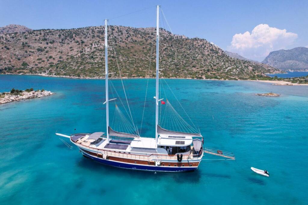 A stunning view of Gulet Babacan, bobbing gently in the waves, against the backdrop of the Aegean Sea and the Bozburun Peninsula.