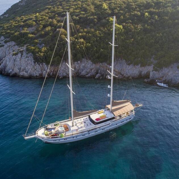 Luxurious Gulet Queen of Salmakis anchored in a tranquil bay, perfect for a relaxing getaway.