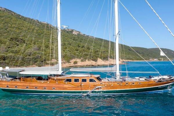 Gulet Bedia Sultan, a 35-meter luxury yacht anchored in Bodrum, surrounded by turquoise waters and lush greenery.