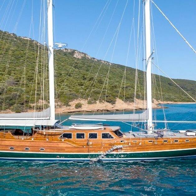 Gulet Bedia Sultan, a 35-meter luxury yacht anchored in Bodrum, surrounded by turquoise waters and lush greenery.